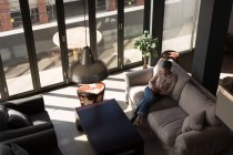 Reife Geschäftsfrau mit Handy auf dem Sofa im Büro — Stockfoto