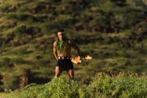 Danseur de feu masculin performant avec bâton de levi de feu près de la plage — Photo de stock