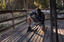 Чоловік прибирає дерев'яні підлоги ганку в сонячний день — стокове фото