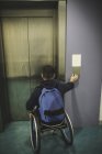 Інвалідний чоловік натискає кнопку ліфта в тренажерному залі — стокове фото