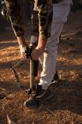 Охотник корректирует лук и стрелу в лесу в солнечный день — стоковое фото