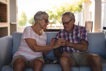 Senior couple checking blood sugar with glucometer at home — Stock Photo
