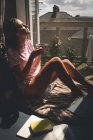 Mulher tomando café preto na sala de estar em casa — Fotografia de Stock