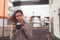 Женщина рассматривает фото с цифровой камерой в городе — стоковое фото