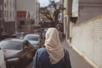 Вид ззаду жінка хіджаб стоїть на тротуарі — стокове фото