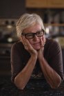 Pensativa mujer mayor en la cocina en casa - foto de stock