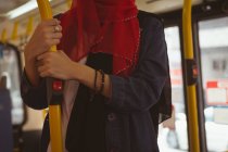 Sección media de la mujer hijab viajando en el autobús - foto de stock