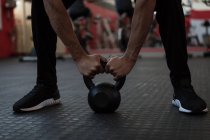 Atleta haciendo ejercicio con kettlebell en el gimnasio - foto de stock
