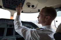 Чоловічий пілот натискає кнопку в приватній кабіні — стокове фото