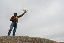 Uomo che aziona un drone volante su una roccia — Foto stock