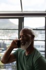 Primer plano del hombre mayor hablando por teléfono móvil en casa - foto de stock