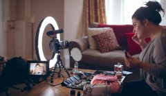 Mujer video blogger aplicando maquillaje en la cara en casa - foto de stock