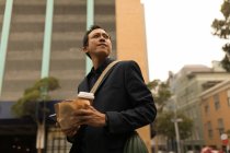 Geschäftsmann hält Essen und Kaffee auf der Straße — Stockfoto