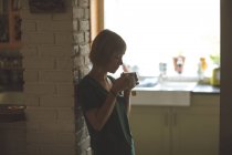Bella donna che ha una tazza di caffè a casa — Foto stock