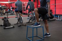 Atleta haciendo ejercicio con pesas en el gimnasio - foto de stock
