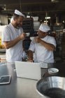 Masculino padeiro tomando café com seu colega de trabalho na padaria — Fotografia de Stock