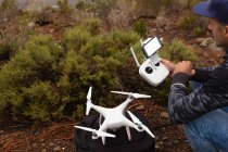 Человек, управляющий летающим дроном в сельской местности — стоковое фото