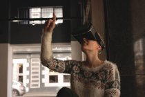 Бізнес-леді, використовуючи гарнітуру віртуальної реальності в кафетерії в офісі — стокове фото