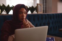 Thoughtful businesswoman in hijab relaxing at cafeteria — Stock Photo