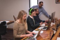 Деловые коллеги, работающие на ноутбуке в офисе — стоковое фото