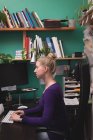 Жінка-виконавця, що працює на комп'ютері за столом — стокове фото