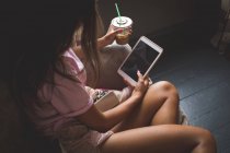Жінка має холодну каву, використовуючи цифровий планшет вдома — стокове фото
