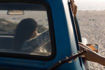 Femme se détendre dans une camionnette à la plage — Photo de stock