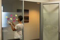 Зріла бізнес-леді працює над липкими нотатками в офісі — стокове фото