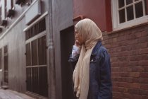 Красива хіджаб жінка розмовляє на мобільному телефоні на алеї — стокове фото