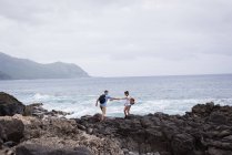 Casal caminhando juntos perto do mar em um dia ensolarado — Fotografia de Stock