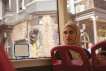 Красивая женщина в хиджабе смотрит в окно автобуса — стоковое фото