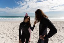 Пара серферов, стоящих на пляже в солнечный день — стоковое фото