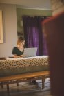Frau benutzt Laptop im heimischen Wohnzimmer — Stockfoto