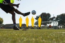 Гравець ногами футбол в галузі спорту на сонячний день — стокове фото