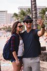 Happy couple taking selfie with mobile phone near beach — Stock Photo