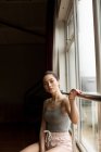 Nachdenkliche Tänzerin blickt durch Fenster im Tanzstudio — Stockfoto