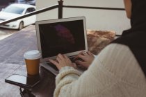 Середина міської хіджаб жінки, що використовує ноутбук у тротуарному кафе — стокове фото