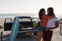Пара обіймає один одного на пляжі в сонячний день — стокове фото