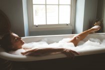 Frau nimmt Schaumbad im Badezimmer zu Hause — Stockfoto