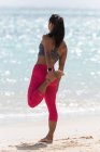 Femme faisant de l'exercice à la plage par une journée ensoleillée — Photo de stock