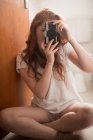 Женщина щелкает фото с камерой дома — стоковое фото