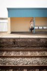 Frau benutzt an sonnigem Tag Handy am Bahnhof — Stockfoto