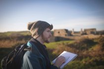 Young male hiker standing with notepad at countryside — Stock Photo