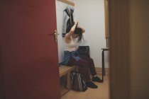 Dançarina amarrando os cabelos no vestiário no estúdio de dança — Fotografia de Stock