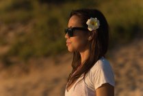 Продумана жінка стоїть на пляжі в сутінках — стокове фото
