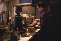 Чоловічий офіціант готує каву в кав'ярні — стокове фото