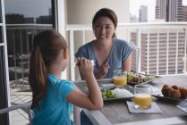 Happy mother and daughter having meal at home — Stock Photo
