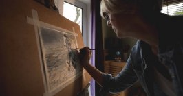 Повзрослевшая художница рисует картину дома — стоковое фото