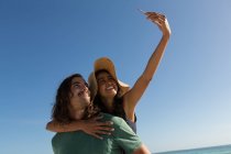 Coppia scattare selfie con cellulare in spiaggia — Foto stock