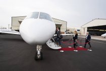 Empresarios abordando en jet privado en terminal - foto de stock